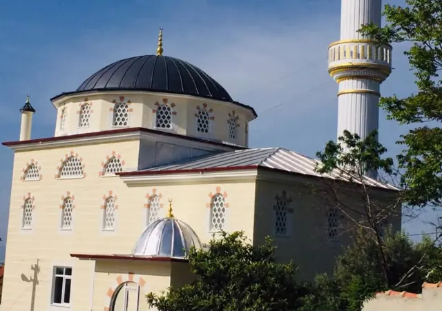 Antrasit kaplı ana kubbe, gümüş renkli giriş kubbesi ve metal çatı kaplaması olan cami