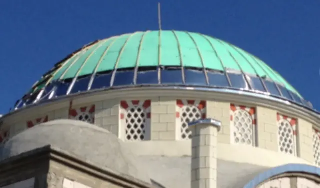 Kaplama yenilemesi sürerken cami kubbesi: yeşil eski levhalar ve yenilenen dilimler