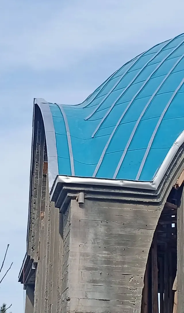Kaba inşaatı süren modern camide turkuaz metal kubbe kaplaması, kenet hatları ve gümüş renkli kenar dönüş profili